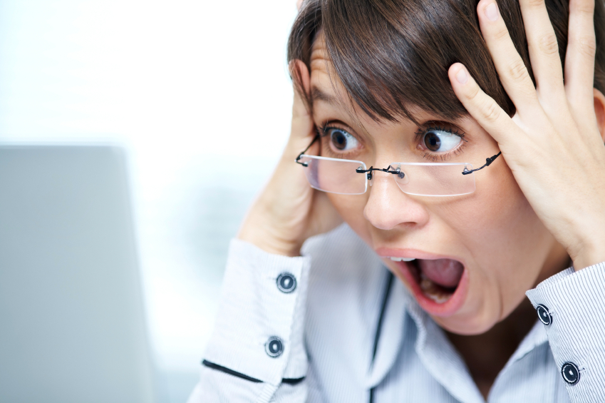 young girl in a horror in front of laptop